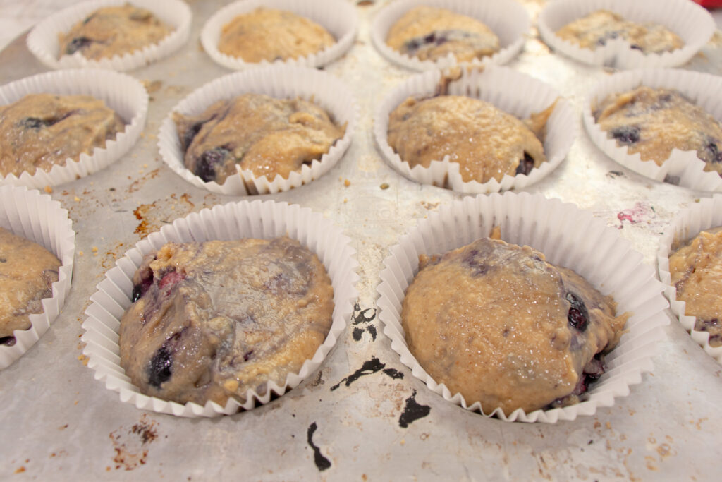 Best blueberry buttermilk muffin recipe with streusel top batter in muffin tins and paper liners