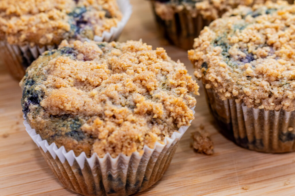Best blueberry buttermilk muffin recipe with streusel top on cutting board close-up